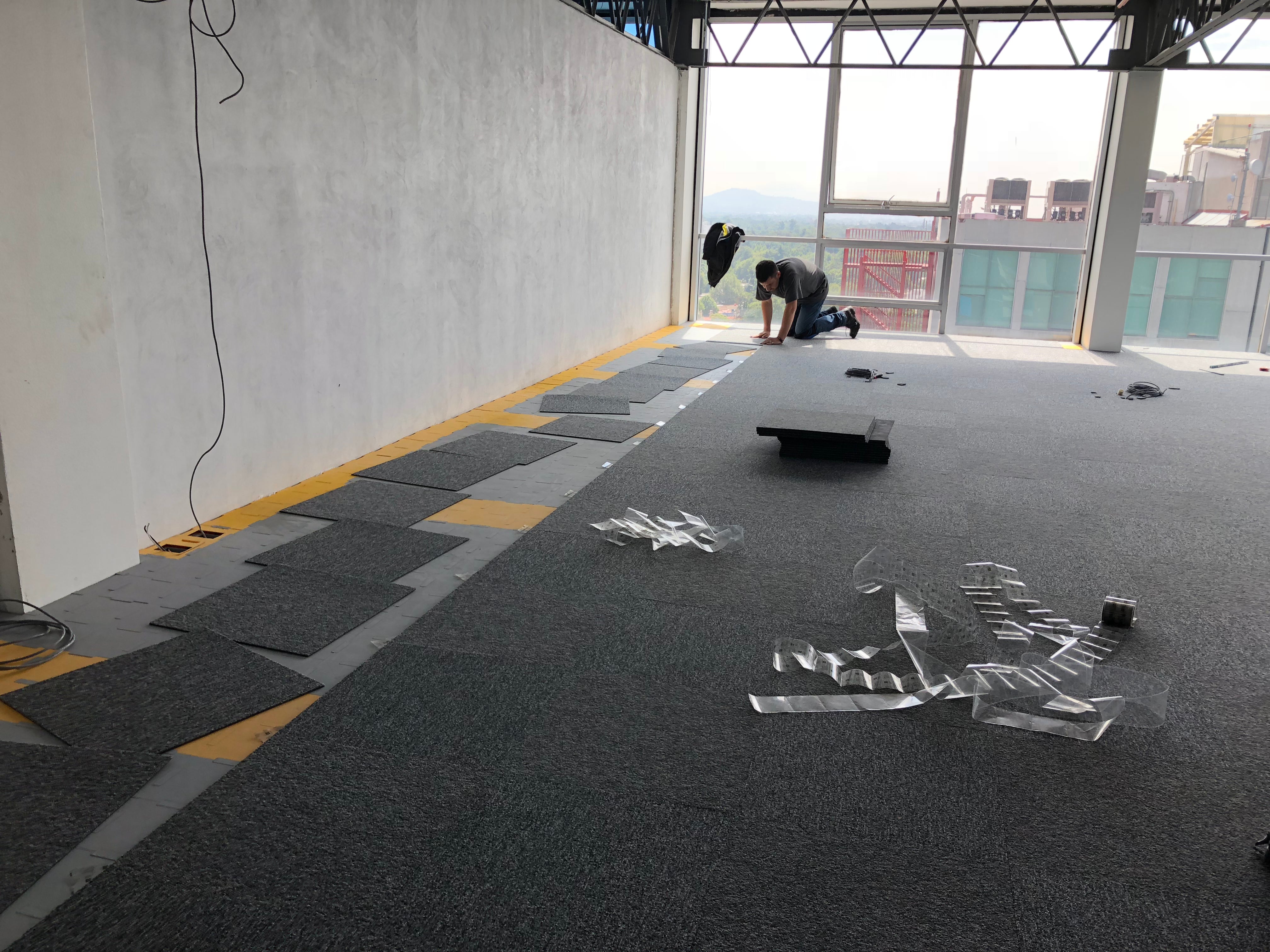 Instalador poniendo alfombra modular sobre ISOGRID